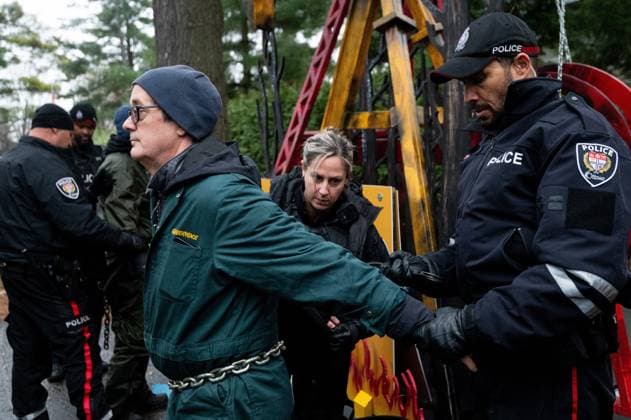 November 21, 2024, Ottawa, On, Canada: Greenpeace climate activist Keith Stewart, left, is handcuffed by Ottawa Police Service officers after being arrested by the OPS for taking part in a sit-in styled protest calling for greater climate change awareness by Conservative Leader Pierre Poilievre, outside of Stornoway, the official residence of the country s official opposition, in Ottawa, on Thursday, Nov. 21, 2024. Ottawa Canada - ZUMAc35_ 20241121_zaf_c35_010 Copyright: xSpencerxColbyx