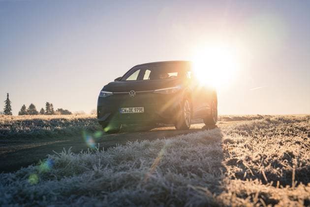 Ein Auto steht auf einem frostigen Feld im Winter, die Sonne scheint intensiv im Hintergrund, Car Sharing, Elektro Auto, Volkswagen ID 5, Gechingen, Hecken und Gäu Region, Schwarzwald, Deutschland, Europa A car parked in a frosty field in winter, the sun shining intensely in the background, car sharing, electric car, Volkswagen ID 5, Gechingen, Hecken und Gäu region, Black Forest, Germany, Europe Copyright: imageBROKER ManuelxKamuf iblmlk12041733.jpg