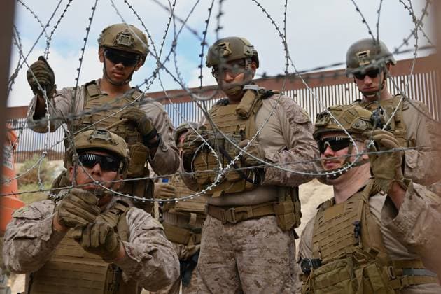 February 6, 2025, Tijuana, Baja California, Mexico: Members of the US Marine Corps install concertina wire along the US-Mexico border wall in San Diego, California, seen from Tijuana, Mexico in between the San Diego-Tijuana border fences of Colonia Libertad on Thursday, February 06, 2025. The Defense Department deployed 1,600 active-duty troops to the border during US President Donald Trumpâ€⠢s first week in office. Tijuana Mexico - ZUMAm180 20250206_zip_m180_008 Copyright: xCarlosxA.xMorenox
