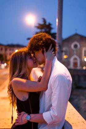 Affectionate young couple kissing inon a bridge at night, Verona, Italy model released, Symbolfoto, GIOF07024