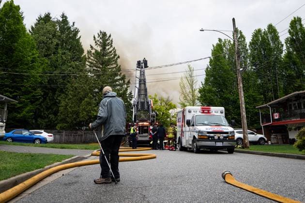 May 10, 2025, North Vancouver, Bc, CANADA: A man watches as the North Vancouver Fire Department fights a fire at Silverlynn Apartments, a three-storey seniors housing complex, in North Vancouver, B.C., Saturday, May 10, 2025. North Vancouver CANADA - ZUMAc35_ 20250510_zaf_c35_024 Copyright: xEthanxCairnsx