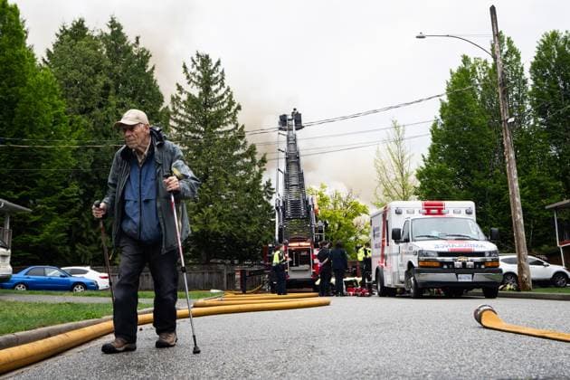 May 10, 2025, North Vancouver, Bc, CANADA: A man walks as the North Vancouver Fire Department fights a fire at Silverlynn Apartments, a three-storey seniors housing complex, in North Vancouver, B.C., Saturday, May 10, 2025. North Vancouver CANADA - ZUMAc35_ 20250510_zaf_c35_037 Copyright: xEthanxCairnsx