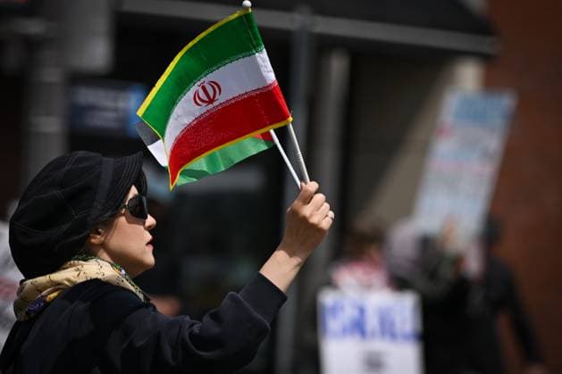 Woman With Israeli Flag Attacked During Edmonton Pro-Palestine Protest EDMONTON, CANADA JUNE 22: A protester holds Iranian flags as members of the local Palestinian diaspora, joined by Iranian and other Middle Eastern Muslim protesters, along with local activists, gather on White Avenue in Edmonton for the Hands Off Palestine, Iran, Syria, Yemen, Lebanon protest on June 22, 2025, in Edmonton, Alberta, Canada. Edmonton Canada Copyright: xArturxWidakx originalFilename: widak-womanwit250622_np8hX.jpg