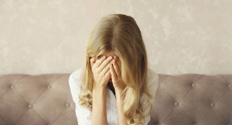 Aufgewühlte, traurige, weinende Frau, die ihre Augen und ihr Gesicht mit den Händen bedeckt, während sie seelisches oder körperliches Leid erfährt, Müdigkeit, die auf der Couch in einem Zimmer zu Hause sitzt Upset sad crying woman covering her eyes and face with her hands while experiencing mental or physical suffering, fatigue sitting on the couch in room at home Copyright: imageBROKER VeronikaxKorneva ibxiqx14273005.jpg ,model released, Symbolfoto ,property released