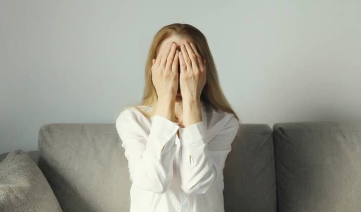 Aufgewühlte, traurige, weinende Frau, die ihre Augen und ihr Gesicht mit den Händen bedeckt, während sie unter Depressionen, Stress, Müdigkeit und seelischem Leid leidet und zu Hause auf der Couch sitzt Upset sad crying woman covering her eyes and face with her hands while experiencing depression, stress, fatigue, mental suffering sitting on the couch at home Copyright: imageBROKER VeronikaxKorneva ibxiqx14273014.jpg ,model released, Symbolfoto ,property released
