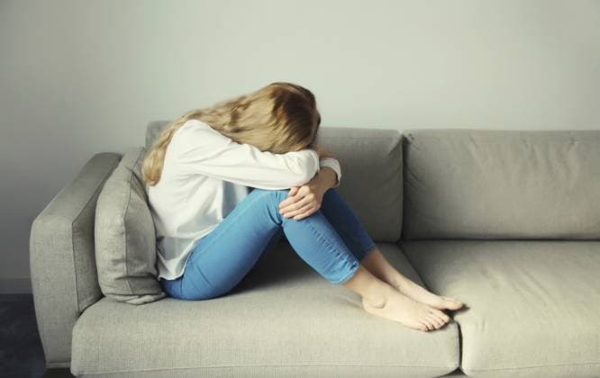 Aufgewühlte, traurige, weinende Frau, die ihre Augen und ihr Gesicht mit den Händen bedeckt, während sie unter Depressionen, Stress, Müdigkeit und seelischem Leid leidet und zu Hause auf der Couch sitzt Upset sad crying woman covering her eyes and face with her hands while experiencing depression, stress, fatigue, mental suffering sitting on the couch at home Copyright: imageBROKER VeronikaxKorneva ibxiqx14273016.jpg ,model released, Symbolfoto ,property released