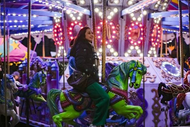 (251115) -- VANCOUVER, Nov. 15, 2025 -- A visitor enjoys a merry-go-round at the Vancouver Christmas Market in Vancouver, British Columbia, Canada, Nov. 14, 2025. The annual festive event features more than 110 wooden huts offering various handicrafts, traditional European food, drink, and souvenirs, along with live performances. This year s market opened here on Thursday and will run until Dec. 24. (Photo by Xinhua) CANADA-VANCOUVER-CHRISTMAS MARKET LiangxSen