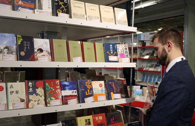 (260311) -- LONDON, March 11, 2026 -- A man visits the China Pavilion of the 2026 London Book Fair in London, Britain, March 10, 2026. At Olympia London, where the 2026 London Book Fair opened Tuesday, the China pavilion stands out not merely for its expansive footprint, but for the comprehensive publishing ecosystem it showcases. The Chinese publishing delegation has arrived with an impressive portfolio of over 4,000 titles and a packed schedule of more than 40 events. Spanning the three-day fair, the agenda ranges from high-profile new book launches and author talks to rights exchanges and industry forums. TO GO WITH Feature: Two-way street -- China s delegation highlights cultural synergy, tech fusion at London Book Fair ) BRITA