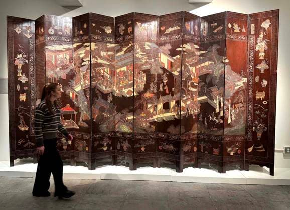 March 19, 2026, New York, New York, USA: A woman views an inscribed twelve-panel lacquer Birthday coromandel screen, Qing dynasty, Kangxi period, estimate $50,000 - $70,000, seen on display during the press preview for Sotheby s New York Inaugural Asian Art Sales, the first ever held at the Breuer Building. New York USA - ZUMAk03_ 20260319_zaf_k03_022 Copyright: xNancyxKaszermanx