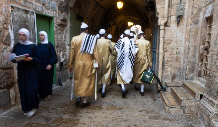 Ultra-Orthodox Jewish men pass two Moslem women who make their way into the Haram al Sharif, or Temple Mount, where the al-Aqsa Mosque is located, as Jews hold mass prayers in the Moslem Quarter in Jerusalem s Old City on Wednesday, September 30, 2026. During the week of Sukkot, or the Feast of Tabernacles, Thousands of Jews, mostly ultra-Orthodox, pack a street leading to a gate, which was closed, leading into the Temple Mount or the Ḥaram al Sharif where the Al Aqsa Mosque is located. JER20260930009 JimxHollander