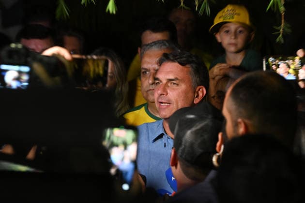 (261005) -- BRASILIA, Oct. 5, 2026 -- Flavio Bolsonaro (C), presidential candidate of Brazil s Liberal Party, speaks after the announcement of the first-round results of the presidential election in Brasilia, Brazil, Oct. 4, 2026. Brazil will hold a presidential runoff on Oct. 25 as official results showed Sunday that no candidate secured a majority of valid votes in the first round. According to results released by the Superior Electoral Court, with over 99 percent of the ballots counted, Flavio Bolsonaro, presidential candidate of Brazil s Liberal Party, garnered about 47 percent of valid votes while incumbent President Luiz Inacio Lula da Silva of the Workers Party came in second with about 45 percent. Under Brazil s electoral ru
