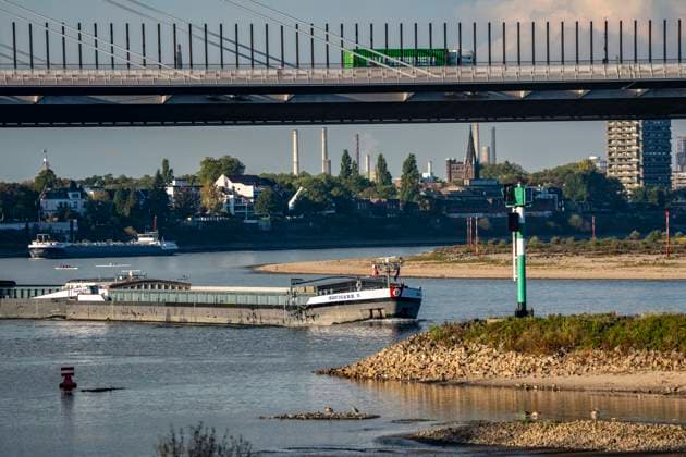 Extremes Niedrigwasser am Rhein, hier zwischen DU-Neuenkamp und DU-Ruhrort, Rheinbrücke Neuenkamp, Autobahn A40, LKW Verkehr, trocken gefallenes Ufer, Pegel zur Zeit der Aufnahme bei 131cm in DU-Ruhrort, über 20cm unter der bisherigen je gemessnen Tiefstmarke von 2018, starke Einschränkungen für die Binnenschifffahrt, im Hintergrund die Friedrich-Eber-Brücke über den Rhein bei DU-Ruhrort, NRW, Deutschland Rhein Niedrigwasser