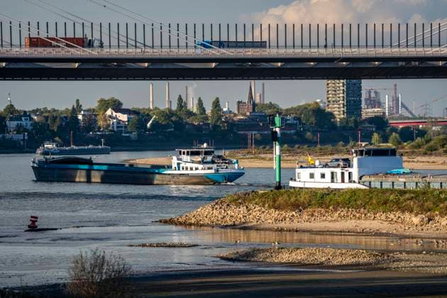 Extremes Niedrigwasser am Rhein, hier zwischen DU-Neuenkamp und DU-Ruhrort, Rheinbrücke Neuenkamp, Autobahn A40, LKW Verkehr, trocken gefallenes Ufer, Pegel zur Zeit der Aufnahme bei 131cm in DU-Ruhrort, über 20cm unter der bisherigen je gemessnen Tiefstmarke von 2018, starke Einschränkungen für die Binnenschifffahrt, im Hintergrund die Friedrich-Eber-Brücke über den Rhein bei DU-Ruhrort, NRW, Deutschland Rhein Niedrigwasser