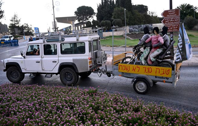 A jeep pulls an effigy of Hamas terrorists kidnapping an Israeli woman at a protest of families and supporters of Israelis murdered by Hamas, on the third anniversary, of the deadliest day in Israel s history outside the Israeli Knesset, Parliament, in Jerusalem, on Wednesday, October 7, 2026. Demonstrators demand a state independent inquiry into the government s security failures, a request rejected by Israeli Prime Minister Benjamin Netanyahu. The banner reads The people shall remember their sons and daughters who were murdered a reference to the Yizkor prayer, with the date 27 10, the day of the upcoming general elections in Israel that are seen as a referendum on Netanyahu s power. JER2026100717 DEBBIExHILL