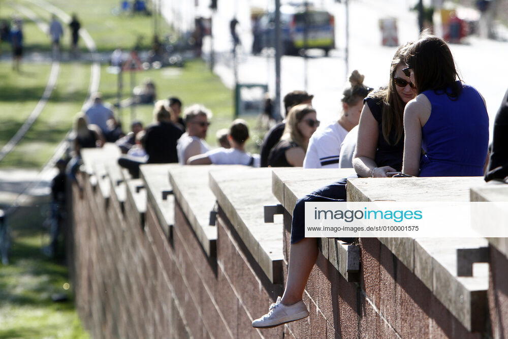 Sonnenhungrige in großer Zahl genießen trotz Coronavirus-Krise, Ausgangsbeschränkungen und Kontaktverboten die warmen Temperaturen und die Sonnenstrahlen auf der Treppe einer Brücke über den Main in der Innenstadt Frankfurt und halten nicht immer den Mindestabstand ein; Hessen, Deutschland