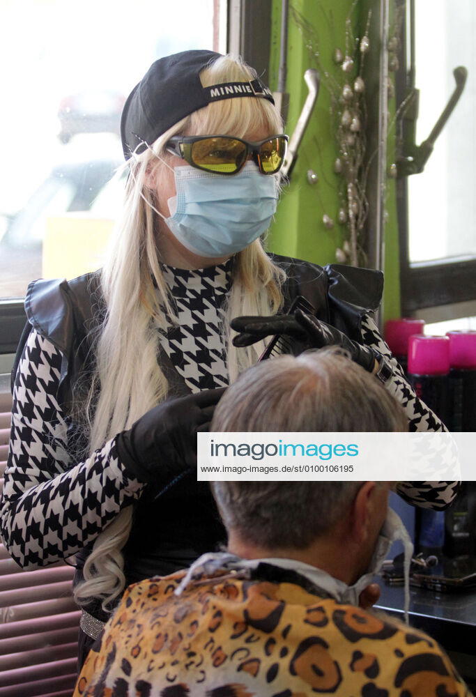 Belgrade(Serbia) Coronavirus Covid-19 Life loosening measures Friseur hair stylist studio Goca Gotza open after 43 days state of emergency.Friseour hairdresser Gordana working with protection mask,gloves and glasses