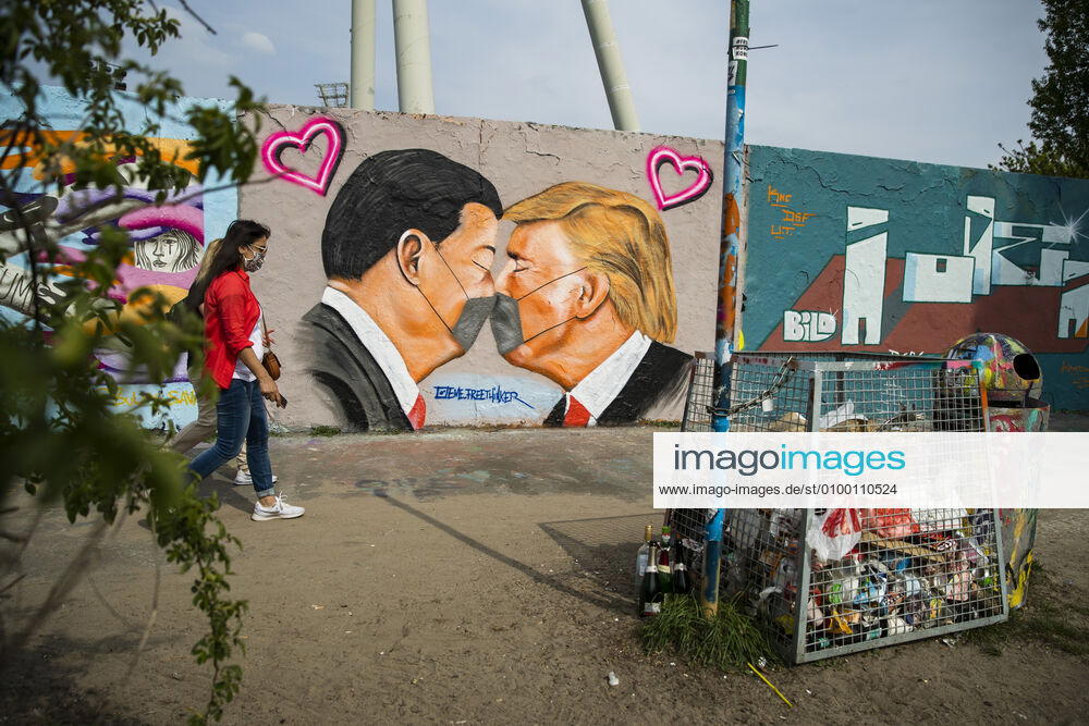 Grafitti des Kuenstlers Eme Freethinker mit USA Praesident Donald Trump und Chinesischer Praesident Xi Jinping, die sich mit einer Mundschutzmaske kuessen, am Mauerpark in Berlin am 28. April 2020. Seit gestern ist in der Bahn, in Trams und Bussen pflicht, eine Protektion fuer Nase und Mund zu tragen. Ab morgen gilt die Pflicht auch fuer den Einzelhandel. Coronavirus in Berlin