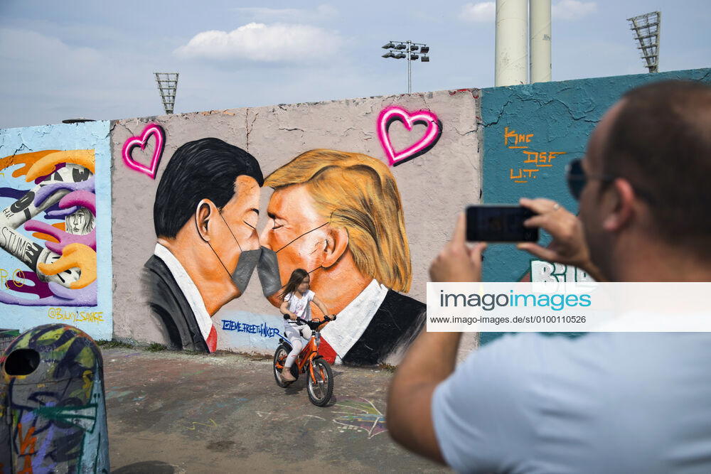 Grafitti des Kuenstlers Eme Freethinker mit USA Praesident Donald Trump und Chinesischer Praesident Xi Jinping, die sich mit einer Mundschutzmaske kuessen, am Mauerpark in Berlin am 28. April 2020. Seit gestern ist in der Bahn, in Trams und Bussen pflicht, eine Protektion fuer Nase und Mund zu tragen. Ab morgen gilt die Pflicht auch fuer den Einzelhandel. Coronavirus in Berlin