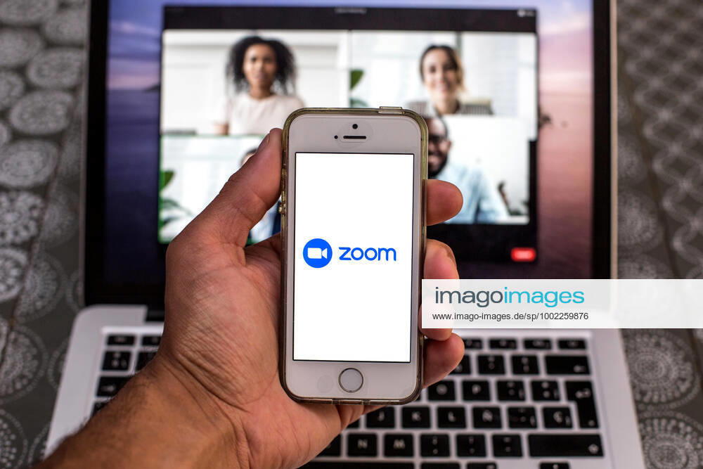 In this photo illustration, the Zoom app seen displayed on a smartphone screen and a Zoom Desktop on a laptop in the background. Barcelona Spain - ZUMAd159 20210420_zia_d159_092