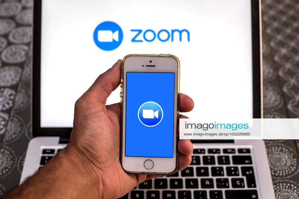 In this photo illustration, the Zoom app seen displayed on a smartphone screen and a Zoom logo on a laptop in the background. Barcelona Spain - ZUMAd159 20210420_zia_d159_093
