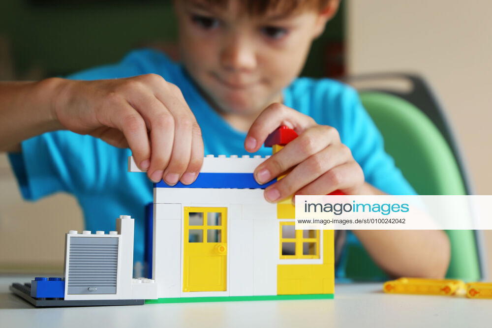 Junge baut mit Bausteinen ein Haus (Model released)