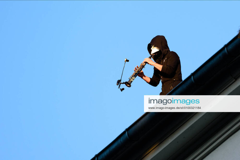 The musician Junk-E-cat can be seen while he gives a spontaneous concert on the roof of a house. The Berlin-based musician Junk-E-cat combines acoustic and electronic elements and seamlessly combines a selection of reed instruments with finger drumming and live looping. Since 4 May, open-air meetings with up to 50 participants are generally permit-free, provided that distance and hygiene rules are observed. Berlin Germany - ZUMAs172 20200509_zap_s172_001