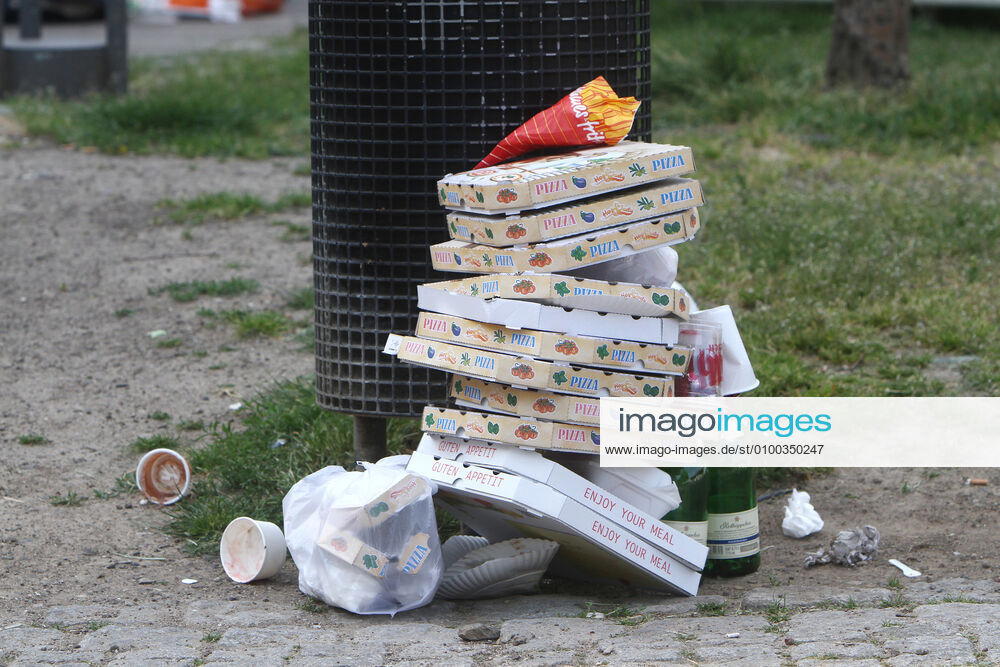 Pizza Schachteln stapeln sich nach einem Außer Haus Verzehr neben geleerten Sektflaschen vor einem überfüllten Mülleimer in der Altstadt von Köln, Nordrhein Westfalen, Deutschland