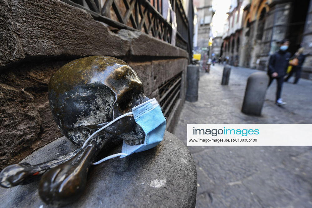 A protective mask is placed on a statue of a skull, in Naples city. Government Decree declaring all of Italy a protected area to combat Covid-19 - Coronavirus infection.