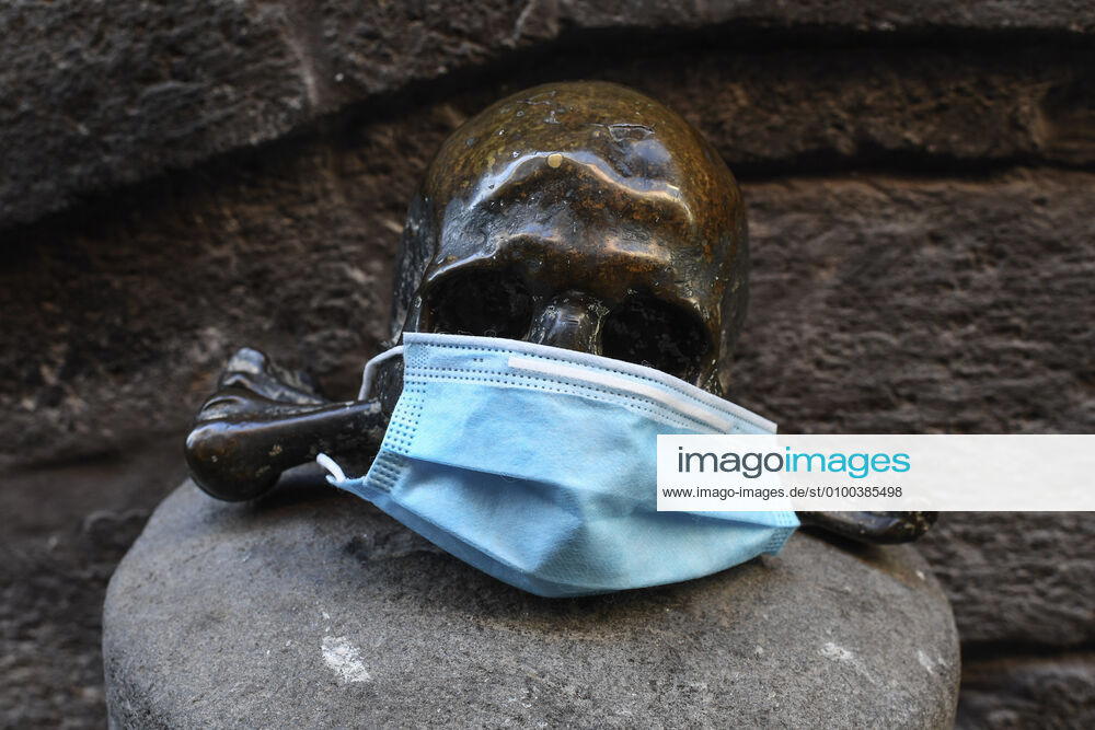 A protective mask is placed on a statue of a skull, in Naples city. Government Decree declaring all of Italy a protected area to combat Covid-19 - Coronavirus infection.