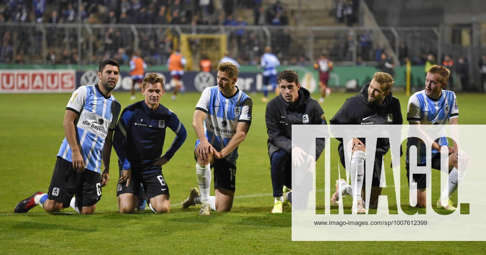 Fussball DFB-Pokal 2021 2022, 2.Runde, TSV 1860 München - FC Schalke 04, im Grünwalder Stadion. v.l. Stephan Salger (1860 München), Erik Tallig (TSV 1860 München), Dennis Dressel (TSV 1860 München), Phillipp Steinhart (1860 München), Yannick Deichmann (TSV 1860 München) und Fabian Greilinger (TSV 1860 München) knieen vor den Fans