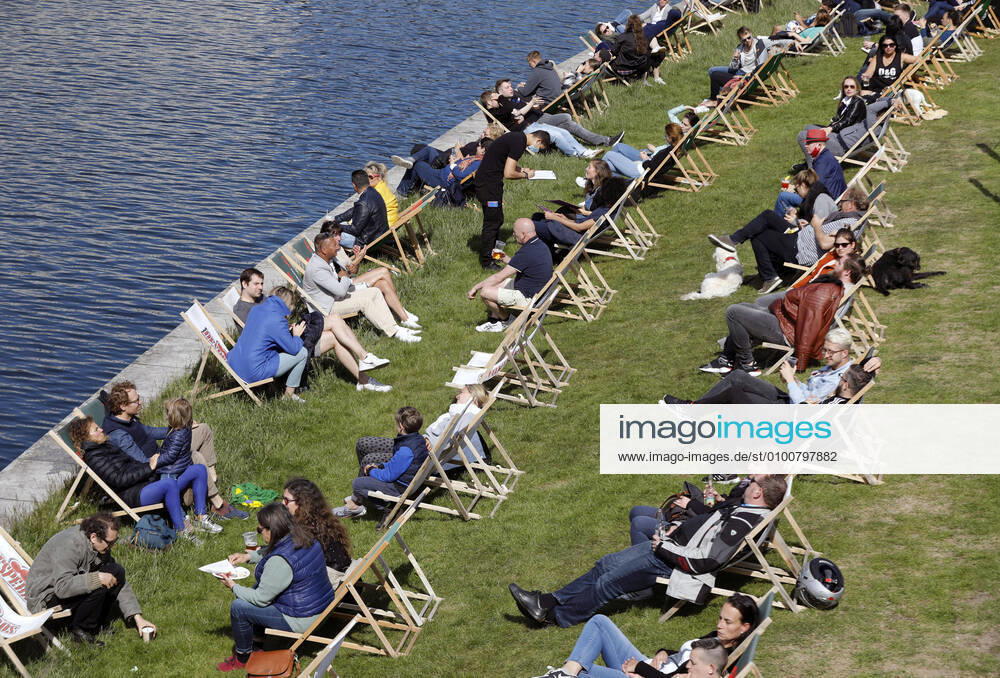 Corona - Lockerungen Berlin, DEU, 17.05.2020 - Ein Ober mit Gesichtsmaske bedient Gaeste in einem gut besuchten Cafe an der Spree in Berlin. Deutschland oeffnet sich langsam wieder. Nach dem Lockdown duerfen Geschaefte, Cafes und Restaurants jetzt nach und nach wieder Kunden bedienen. Dabei muessen Gaeste und Bedienung Abstands- und Hygieneregeln einhalten. Berlin Berlin Deutschland