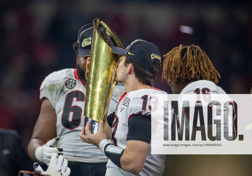 Georgia quarterback Stetson Bennett (13) kisses the trophy after College Football Playoff National Championship game action between the Georgia Bulldogs and the Alabama Crimson Tide at Lucas Oil Stadium in Indianapolis, Indiana. Georgia defeated Alabama 33-18. CSM USA - ZUMAc04_ 20220110_zaf_c04_154