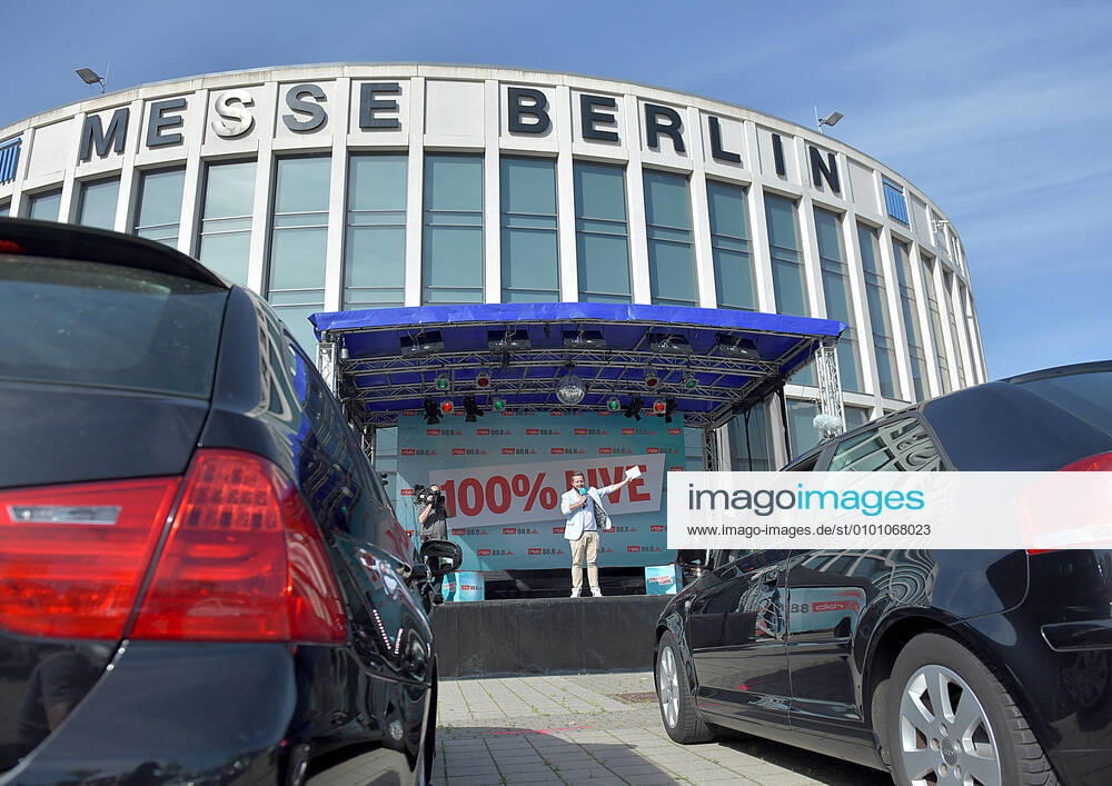 Entertainment Musik, rbb 88.8 90er-Drive-In Konzert, v.l.Tim Koschwitz Radiomoderator vom rbb 88.8 steht auf der Buehne im Autokino am Messedamm Ecke Alte Jaffestrasse Allego charging station.Alle Konzerte finden dabei live statt. Das Publikum sitzt im Auto und hoert über eine eigene Frequenz den Ton im Radio. Berlin