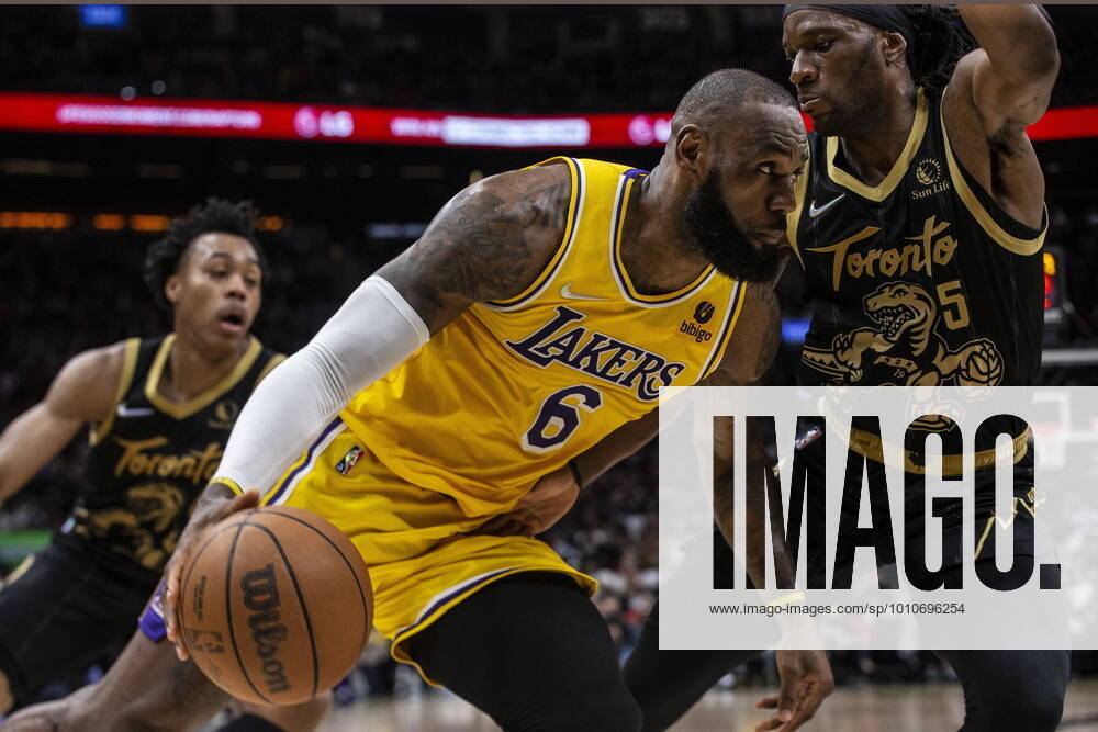 Toronto, ON, CAN: Los Angeles Lakers LeBron James (centre) drives at Toronto Raptors Precious Achiuwa during second half NBA, Basketball Herren, USA basketball action in Toronto on Friday, March 18, 2022. LeBron James; Precious Achiuwa - ZUMAc35_ 20220318_zaf_c35_080
