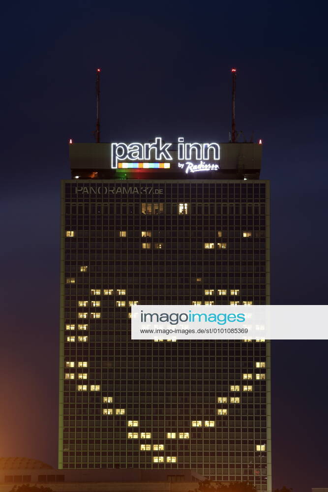 Berlin, Deutschland - Foto: Hotel Park Inn und der Fernsehturm am Alexanderplatz. Das Hotel Park Inn am Alexanderplatz hat waehrend der Corona-Krise einige Fenster so beleuchtet, dass sie zusammen ein Herz bilden.