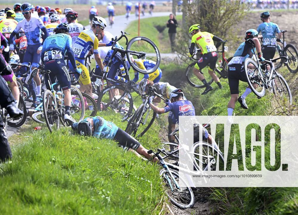 KW12 Wevelgem, Belgium - March 27 : crash of some riders during the UCI World Tour 84th Flanders Classics Gent - Wevelgem - In Flanders Fields cycling race with start in Ieper and finish in Wevelgem on March 27, 2022 in Wevelgem, Belgium, 27 03 2022 ( Motordriver Kenny Verfaillie - Gent - Wevelgem 2022 Cycling Race PhotoNews Panoramic