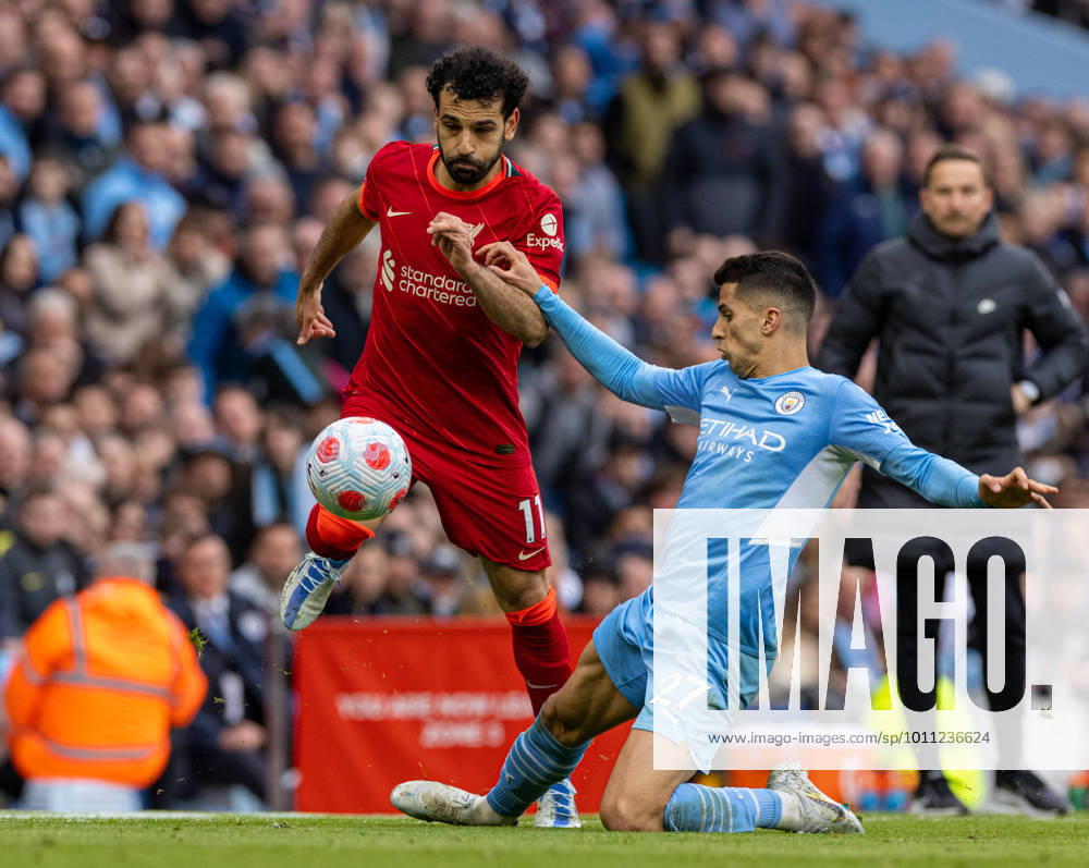 KW14 (220411) -- MANCHESTER, April 11, 2022 -- Liverpool s Mohamed Salah (L) skips over a challenge from Manchester City s Joao Cancelo during the English Premier League match between Manchester City and Liverpool in Manchester, Britain, on April 10, 2022. The game ended in a 2-2 draw. FOR . NOT FOR SALE FOR MARKETING OR ADVERTISING CAMPAIGNS. NO USE WITH UNAUTHORIZED AUDIO, VIDEO, DATA, FIXTURE LISTS, CLUB LEAGUE LOGOS OR LIVE SERVICES. ONLINE IN-MATCH USE LIMITED TO 45 IMAGES, NO VIDEO EMULATION. NO USE IN BETTING, GAMES OR SINGLE CLUB LEAGUE PLAYER PUBLICATIONS. (SP)BRITAIN-MANCHESTER-FOOTBALL-PREMIER LEAGUE-MANCHESTER CITY VS LIVERPOOL Stringer