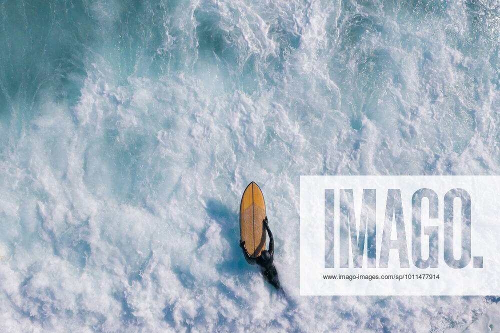 KW16 VLADIVOSTOK, RUSSIA - APRIL 22, 2022: A surfer carries a surfboard in Chernysheva Bay of Ussuri Bay off Russky Island. Yuri Smityuk TASS TS12DF36