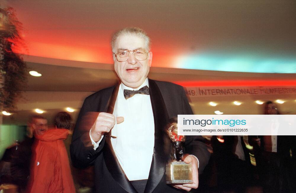 1 Berlinale 99: Festivalleiter Moritz de Hadeln zeigt den Hosenträgerbär, den er als Preis für 20 Jahre Festivalleitung bekam, ein silberner Hosenträger-Bär, wegen de Hadelns Vorliebe für dieses Bekleidungsstück, Spassbär, Spaßbär, Spaß, glücklicher Gewinner, zeigt Stolz seinen Bär mit Hosenträgern, glücklich, Freude, Jubel, Abschlußveranstaltung der INTERNATIONALEN FILMFESTSPIELE in Berlin, internationale, Filmfest, Kino, Prominente, Promi, Gesellschaft, Preis, Filmfestival, Berlin Germany