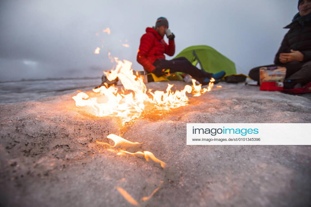 Campfire moves across the glacier as two men camp on a glacier. Pangnirtung, NU, Canada CR_JDIP200518-319539-01,model released, Symbolfoto