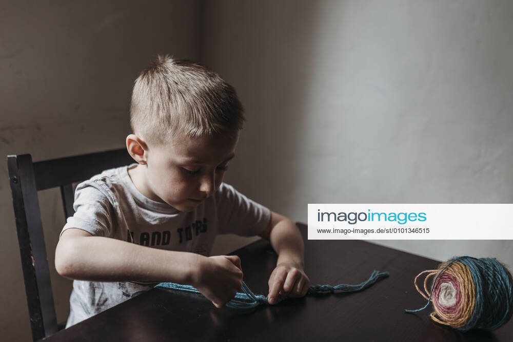 IMAGO Creative: Digitale Welt, Verzicht auf Technologie Young boy knitting with fingers at home during isolation San Diego, CA, United States CR_KESM200409-341162-01,model released, Symbolfoto