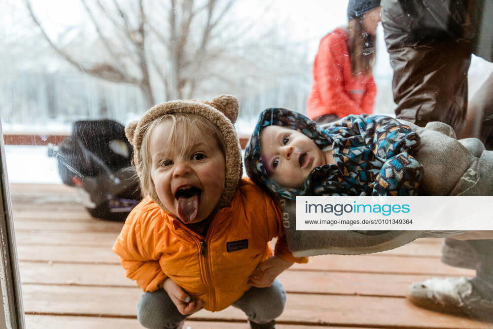 Young kids smile and look through window at uncle during quarantine Jackson, WY, United States CR_PELO200406A-337852-01,model released, Symbolfoto