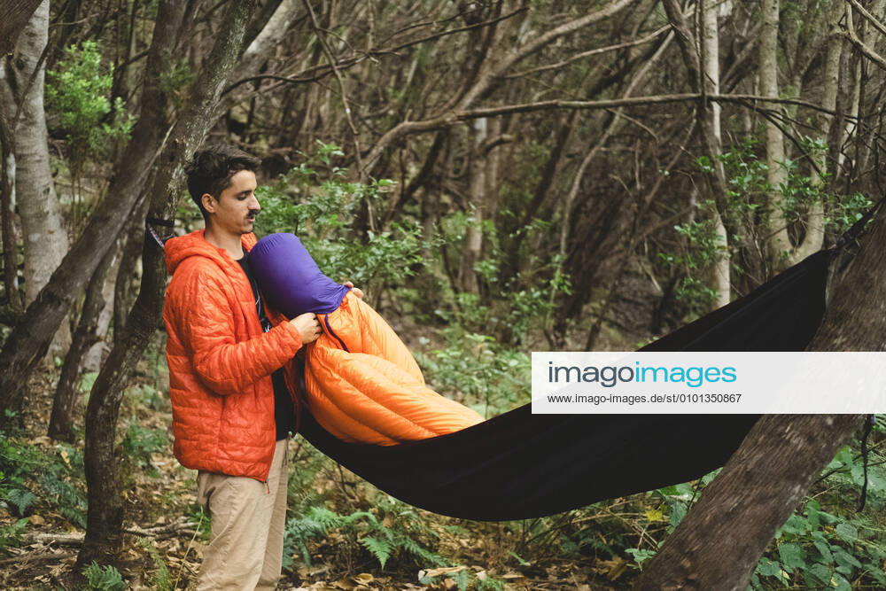 A man packs a sleeping bag and hammock at campsite in the forest Santa Cruz de Tenerife, CN, Spain CR_SEVI200402-201018-01,model released, Symbolfoto