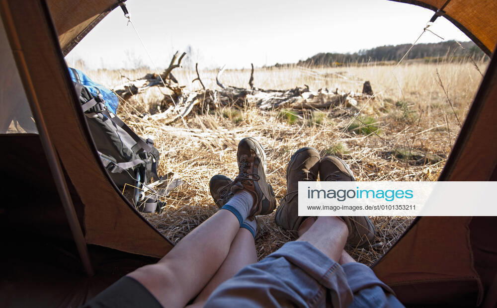 Couple lying inside a tent with their feet outside Woking, England, United Kingdom CR_THHE200515D-395787-01,model released, Symbolfoto