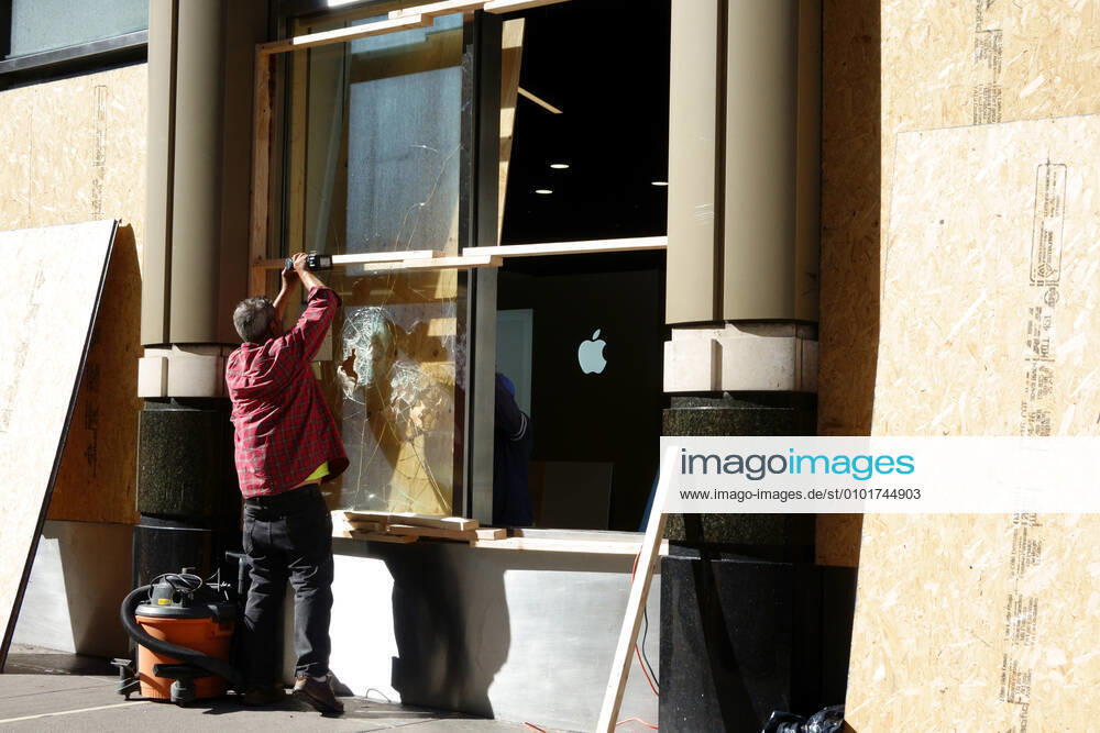 Man repairing broken storefront window after protests and looting, Best Buy, Manhattan. 4031_02_js_3117_repairing_vandalism
