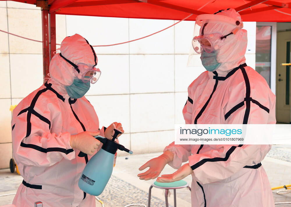 (200624) -- BEIJING, June 24, 2020 -- A medical worker disinfects a colleague s hands at a nucleic acid testing site in Peking University Hospital, Beijing, capital of China, June 24, 2020. Peking University Hospital has strengthened management of the nucleic acid testing site to avoid risk from the crowd gathering. ) CHINA-BEIJING-NUCLEIC ACID TESTING-MANAGEMENT (CN) RenxChao