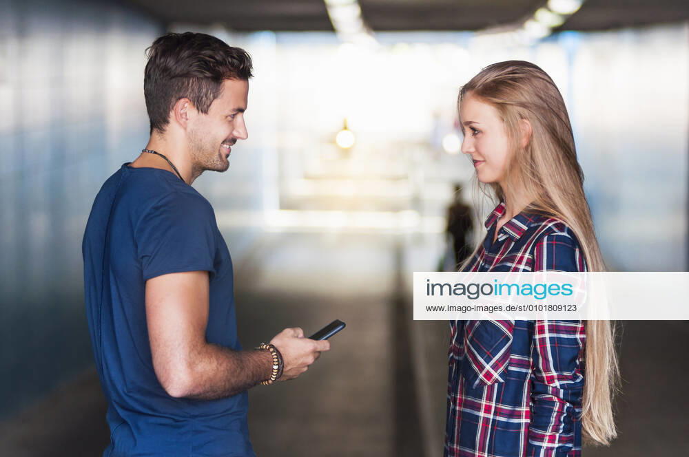 Young man and young woman standing together in an underpass looking at each other model released Symbolfoto DIGF11972