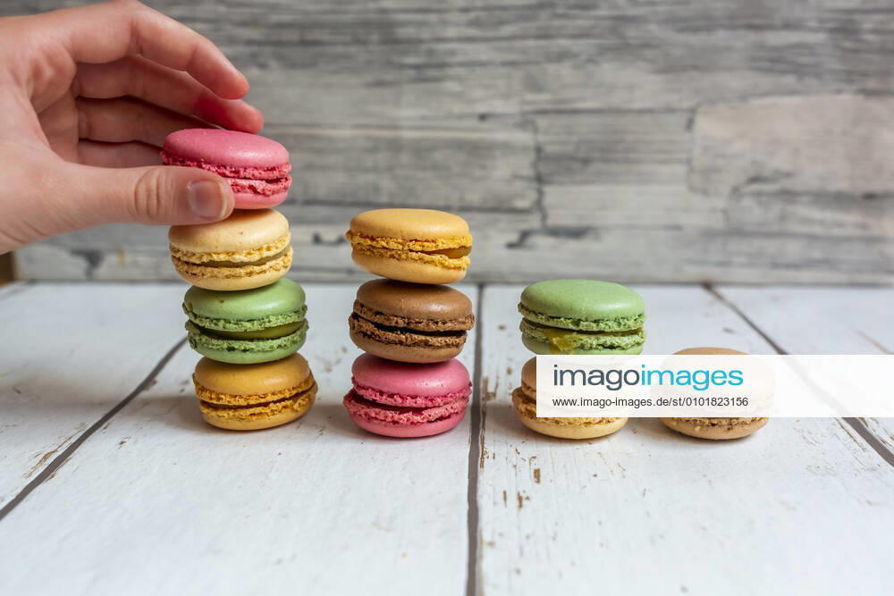 Hand of person picking up macaroon biscuit SARF04572