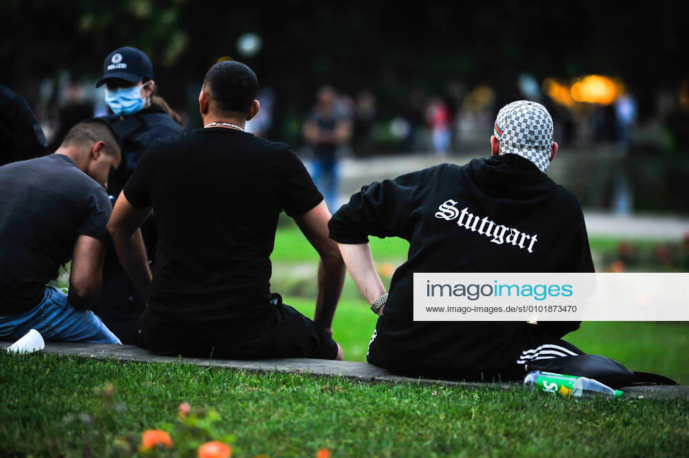 KW26 Jugendliche im Schlossgarten. Eine Woche nach der Krawallnacht in Stuttgart. Abendsstimmung am Eckensee und auf der Königstrasse und Schlossgarten am Freitagabend. Viele Jugendliche ca. 200, manche haben Alkohol dabei. Die Polizei zeigt Präsentz und macht eine Kontrolle von ca. 30-50 Personen von den, die in eine Reihe sitzen. Stuttgart Baden-Wuerttemberg Deutschland