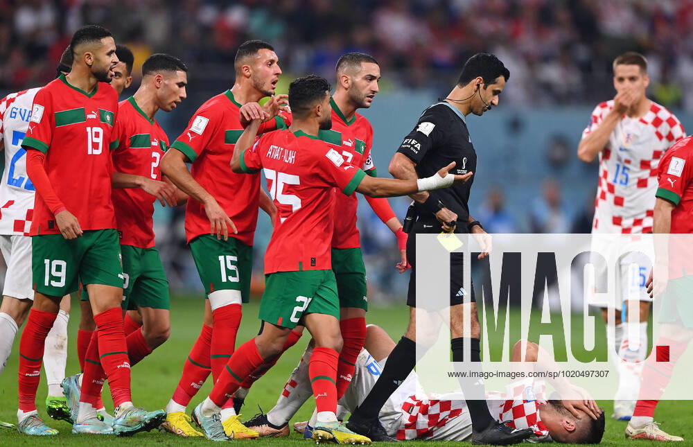 FUSSBALL WM 2022 Spiel um Platz 3 Kroatien - Marokko 17.12.2022 Schiedsrichter Abdulrahman Al Jassim (Katar) wird von Hakim Ziyech, Yahia Attiat Allah, Selim Amallah, Achraf Hakimi und Youssef En-Nesyri (v.re, alle Marokko) nach einer Entscheidung auf Freistoss nach einem Foul an Bruno Petkovic (Boden, Kroatien) bedraengt.